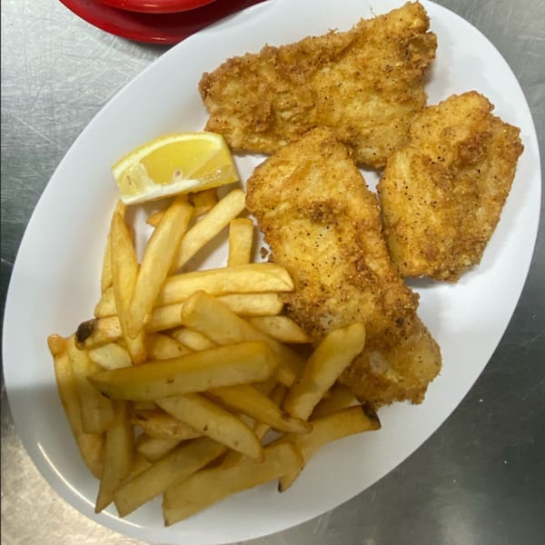 St Clair Coney Island's fried fish and french fries with a lemon wedge on a white plate.