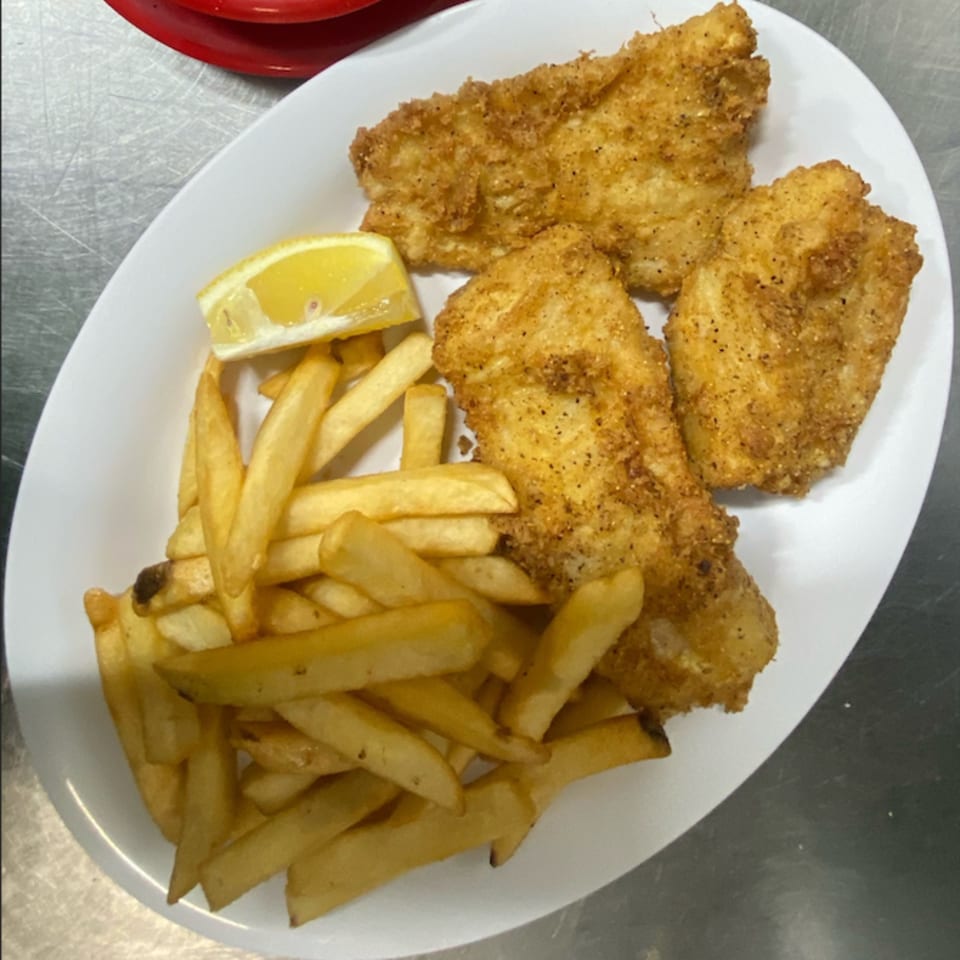 St Clair Coney Island's fried fish and french fries with a lemon wedge on a white plate.
