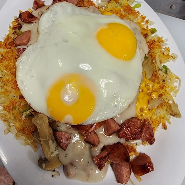 St Clair Coney Island's breakfast skillet with hash browns, sausage, gravy, and two fried eggs.